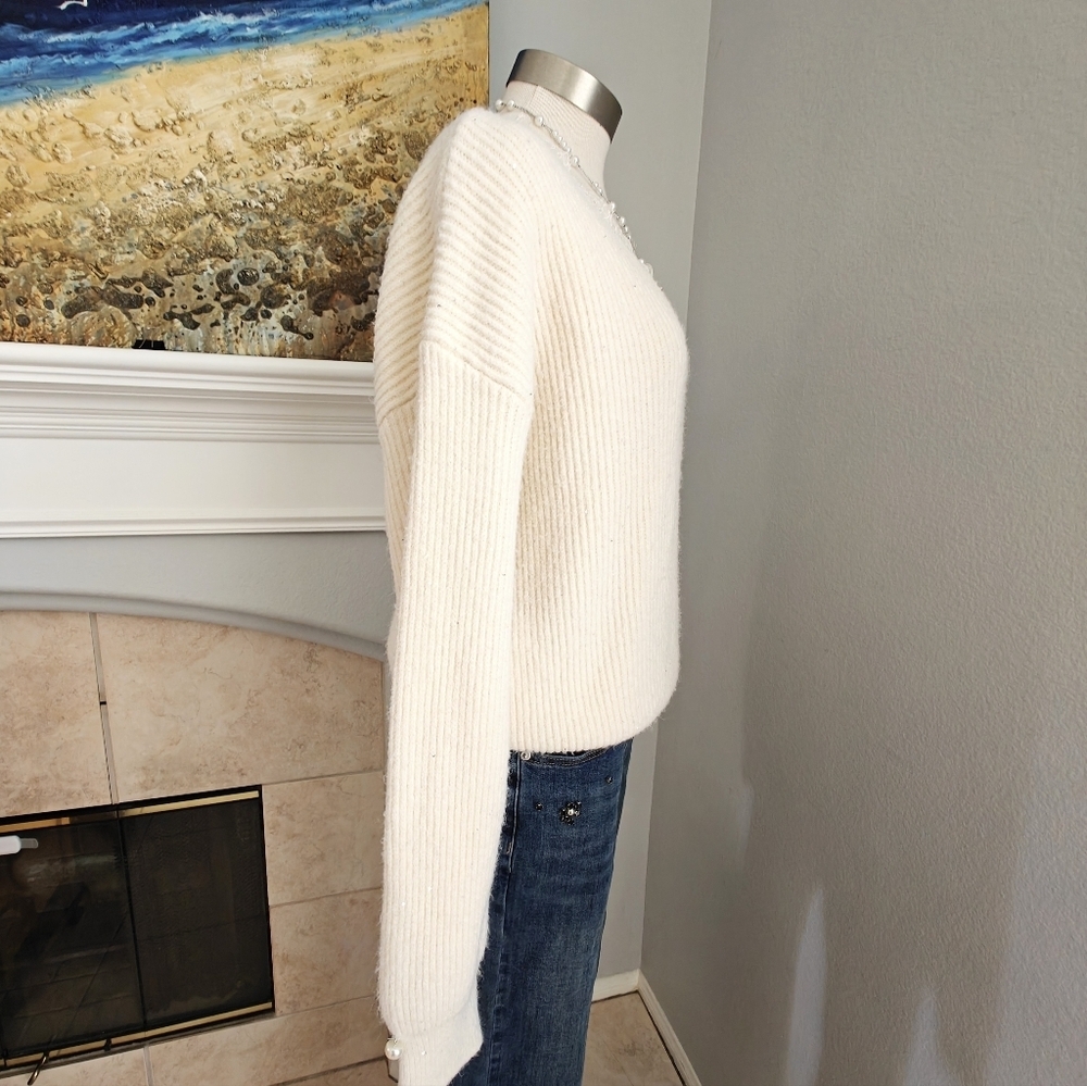 Soft and cozy cream knit sweater featuring a delicate lace trim at the neckline